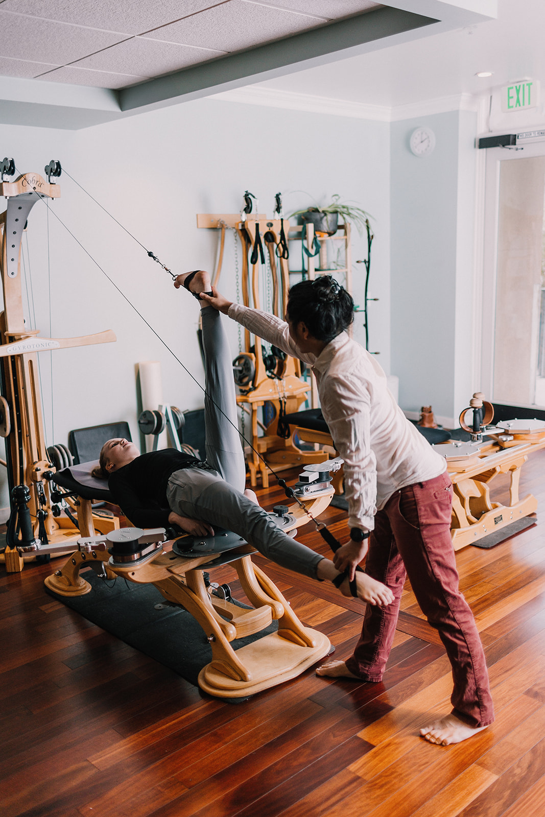 Gyrotonic Trainer Joseph Liu guiding a student on the Gyrotonic Pulley Tower Machine